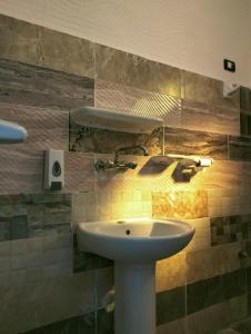een badkamer met een witte wastafel en een spiegel bij Friendo's House & Hot Spring in Siwa