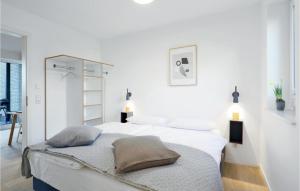 1 dormitorio blanco con 2 camas y 2 lámparas en Beach Front Apartment, en Lembruch
