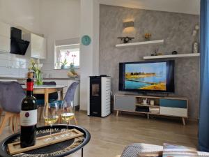 una sala de estar con una botella de vino en una mesa en Apartman Perla, en Biograd na Moru
