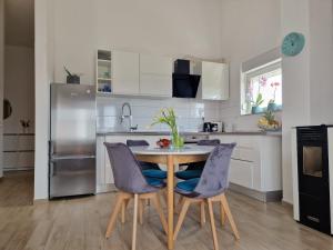 uma cozinha com uma mesa e cadeiras numa cozinha em Apartman Perla em Biograd na Moru