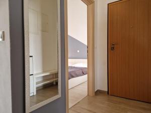 um espelho em frente a um quarto com uma cama em Apartman Perla em Biograd na Moru