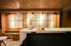 a room with a table with a vase of flowers on it at Miru Kyoto Gion in Kyoto