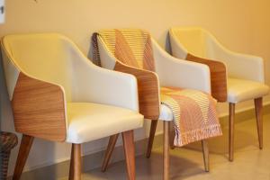 four chairs lined up in a row in a room at Costa Solar Lagoa in Florianópolis