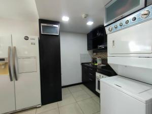 a kitchen with a white refrigerator and a white dishwasher at Torre Bellini in Guayaquil
