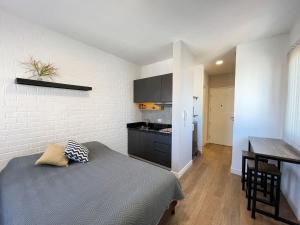 a bedroom with a bed and a kitchen with a table at SPACE BOX in Cochabamba