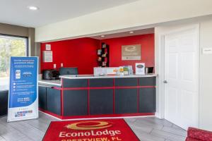 a restaurant with a counter and a red wall at Econo Lodge in Crestview