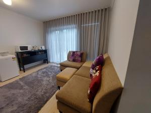 a living room with a couch and a table at bamboo in Apollo Bay +3 photos