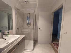 a white bathroom with a shower and a sink at bamboo in Apollo Bay