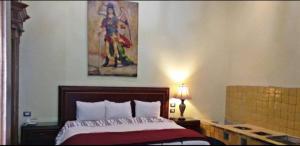 1 dormitorio con 1 cama y una pintura en la pared en Hotel Real Santander, en Puebla