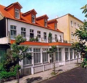 un bâtiment avec un toit orange dans une rue dans l'établissement Haus Sommerwind, à Norderney