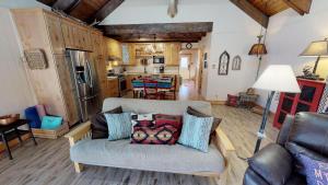a living room with a couch and a kitchen at Tranquil Little Cabin On The River With High Speed Wifi in Red River