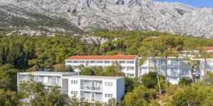 ein weißes Gebäude vor einem Berg in der Unterkunft Aminess Casa Bellevue in Orebić