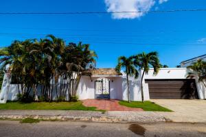 a white house with palm trees in front of it at Caribbean Backyard - Home w Private Pool/Jacuzzi in Aguada