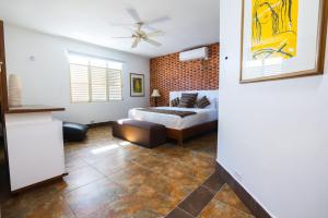 a bedroom with a bed and a couch at Caribbean Backyard - Home w Private Pool/Jacuzzi in Aguada