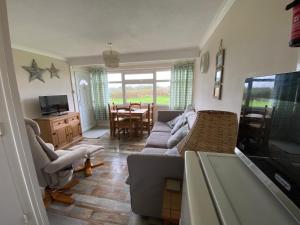 a living room with a couch and a table at East Coast Chalets 300 Dog friendly at California Sands in Scratby