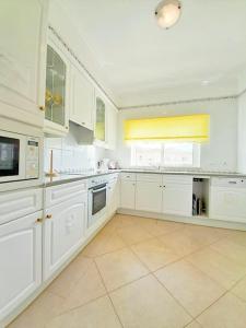 a large white kitchen with white cabinets and appliances at Algarver II-Boavista Golf Fairview Swimpool Apartment in Lagos