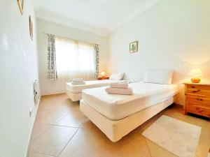 two beds in a white room with a window at Algarver II-Boavista Golf Fairview Swimpool Apartment in Lagos +46 photos