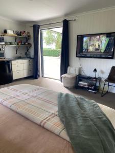 a bedroom with a large bed and a large window at Glenie Cottage BnB Guesthouse in Timaru