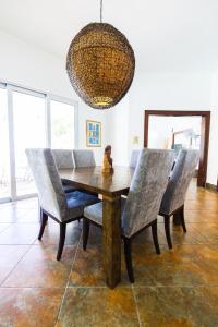 a dining room table with chairs and a chandelier at Caribbean Backyard - Home w Private Pool/Jacuzzi in Aguada