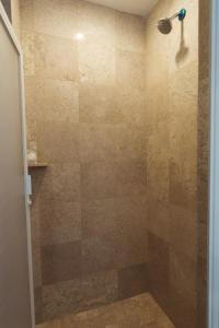 a bathroom with a shower with a glass door at Hoteles Unico Express in León