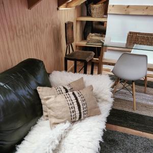 un sofá de cuero negro con 2 almohadas y un escritorio en Vertientes De Pumillahue, Chiloe en Pumillahue