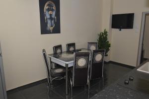 a dining room with a table and chairs and a tv at APART VERSAI in Varna City