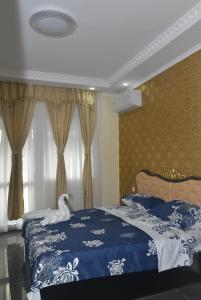 a bedroom with a bed with a blue and white blanket at APART VERSAI in Varna City