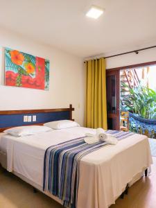 a bedroom with a bed and a large window at Pousada do Tio Zé in Itacaré