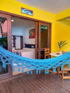 a hammock in a room with a bedroom at Pousada do Tio Zé in Itacaré