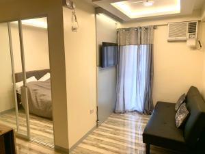 a small room with a bed and a mirror at Allen’s cozy condo in Davao City