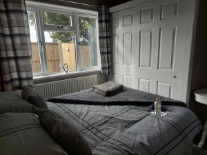 a bed sitting in a room with a window at Love Nest in Deal