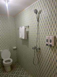 a bathroom with a toilet and a shower in it at Kelingking Tatakan Bungalow in Nusa Penida