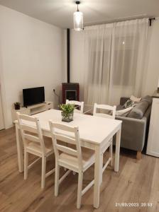 een witte tafel en stoelen in de woonkamer bij Casa Dina in Carballino