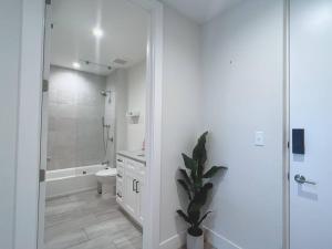 y baño blanco con aseo y ducha. en Luxe & cozy 3Beds,2rooms,EV Gym Near Beaches&Downtown WPB en West Palm Beach