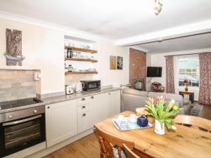een keuken en een woonkamer met een tafel en een bank bij Quarry Cottage in Flushing