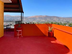 uma varanda com paredes cor-de-laranja e vista para a cidade em Casa Santiago em Oaxaca de Juárez