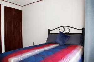 a bedroom with a bed with a colorful blanket at Casa Santiago in Oaxaca City