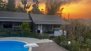 ein Haus mit einem Pool vor einem Sonnenuntergang in der Unterkunft เลอเบสท์พลูวิลล่าเชียงใหม่Lebest Pool Villa Chiangmai in Ban Mai