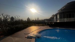 a swimming pool with the sun in the sky at เลอเบสท์พลูวิลล่าเชียงใหม่Lebest Pool Villa Chiangmai in Ban Mai +97 photos