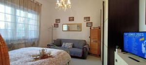 een slaapkamer met een bed en een stoel en een tv bij Lovely Beach House For Two in Torre del Lago Puccini