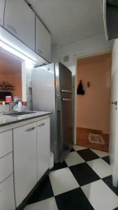 cocina con nevera y suelo a cuadros en blanco y negro en Departamento tipo duplex 2 ambientes Belgrano en Buenos Aires