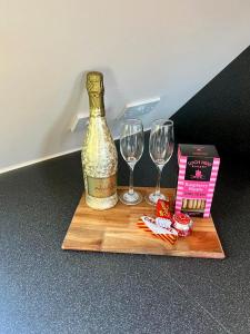 a bottle of wine and two glasses on a cutting board at 1 Loch Ness Heights in Inverness