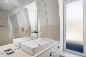 een witte badkamer met een wastafel en een douche bij Les Deux Mariettes São Bento in Lissabon