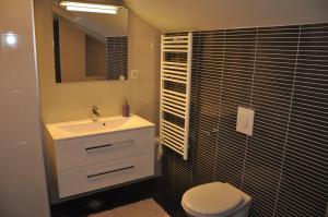 a bathroom with a sink and a toilet and a mirror at Apartment Sea San in Makarska +11 photos