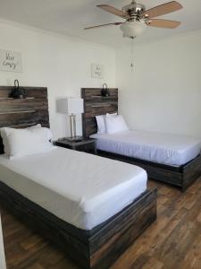 2 łóżka w sypialni z wentylatorem sufitowym w obiekcie Convenient and Comfortable w mieście Macon