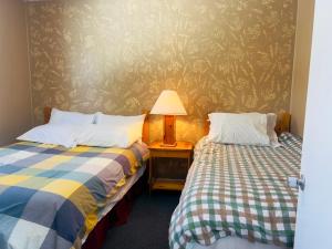 ein Schlafzimmer mit 2 Betten und einer Lampe auf einem Tisch in der Unterkunft Glenview Cottages in Sault Ste. Marie