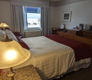 a hotel room with a bed and a window at Auberge des 21 in La Baie