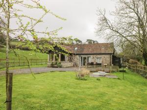 een stenen huis met een tuin ervoor bij Oxbarton in Butcombe