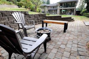 twee stoelen en een tafel en een bank op een patio bij Tranquil And Spacious suite in Anmore in Ioco