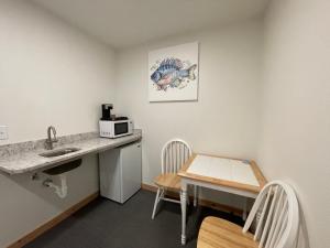 a kitchen with a sink and a table with a microwave at The Inn at Old Town in Bandon